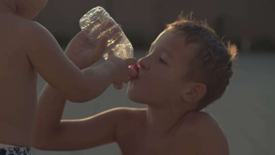 俩小孩喝着同一瓶水