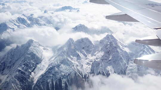 飞机在雪山高原和云海上飞行
