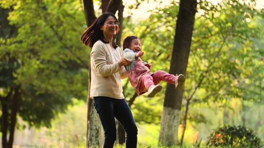 秋天公园里亲子欢乐时光妈妈抱着宝宝转圈
