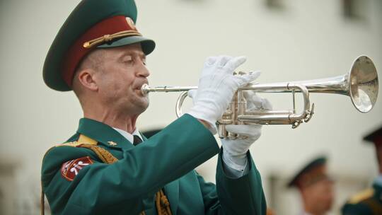 俄罗斯，喀山09-08-2019：管乐器游行——一名身穿绿色服装的男子吹小号