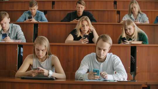 一群学生在手机上发短信
