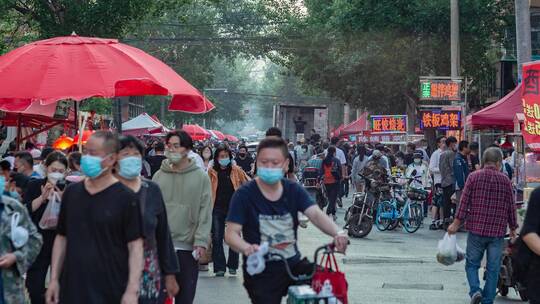 露天菜市场往来购物的市民