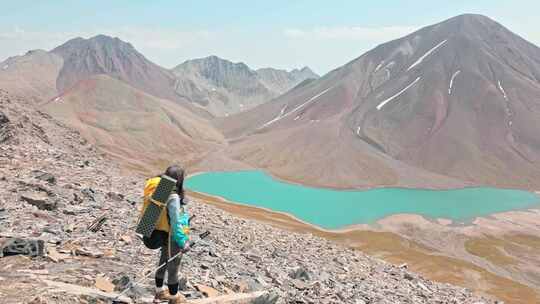 女子徒步旅行者站在山上通过Keltsad