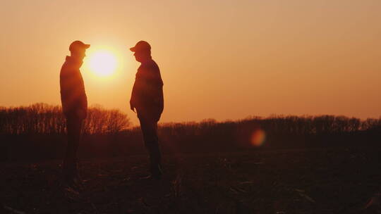 两个农民站在田野里握手