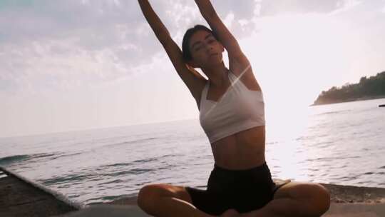 清晨女人在海边练习瑜伽