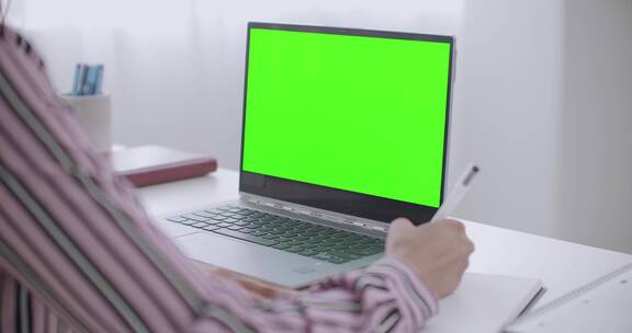 女人面对绿色屏幕写作