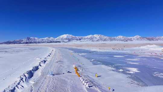 航拍新疆冬季赛里木湖冰封湖面雪山冰湖积雪