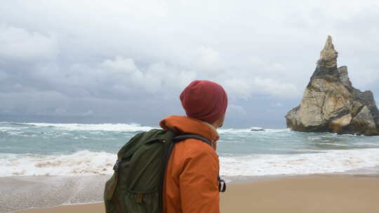 摄影师拍摄海洋海滩上遥远的悬崖
