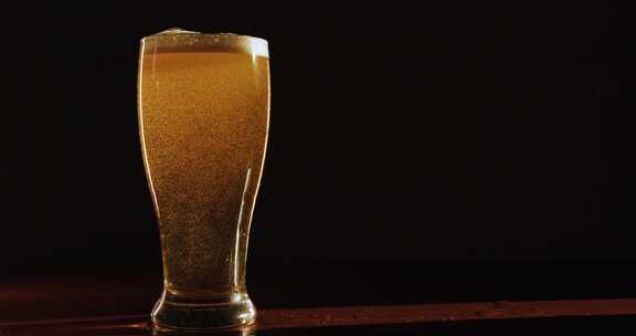 啤酒中的气泡在倒入玻璃杯后猛烈上升到顶部