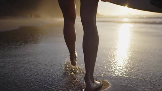 黄昏在沙滩上行走的女人腿部特写