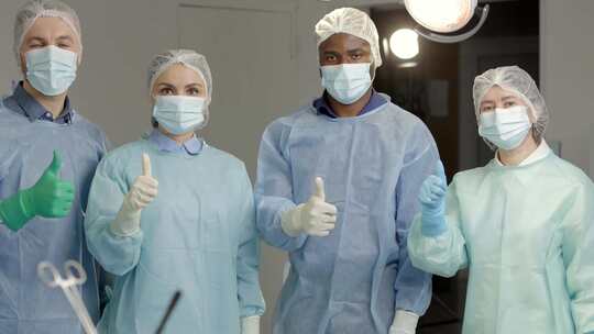 手术成功后，一群戴着口罩的医生站在手术室