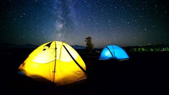 五颜六色的灯光帐篷，夜空和星星的时间流逝
