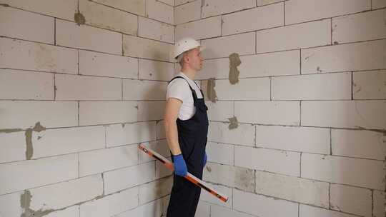 一名戴白色头盔的男性建筑工人在建筑工地上