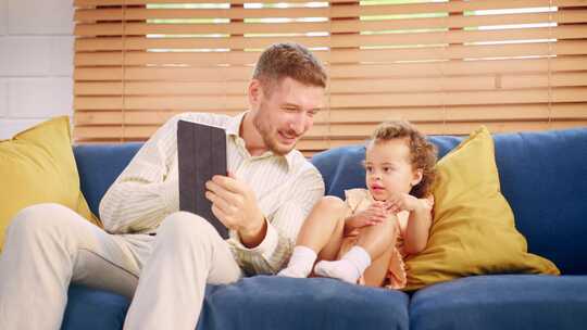 白人父亲在家中客厅与女婴共度闲暇时光。视频素材模板下载