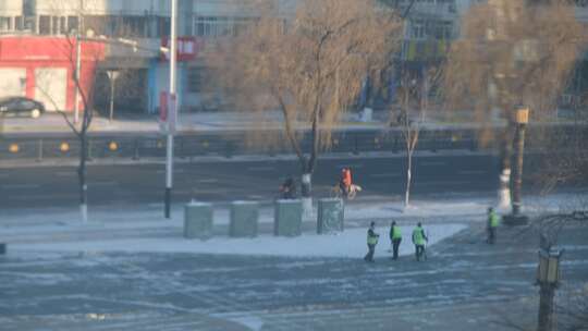 牡丹江市路边打扫积雪的环卫工人和行人