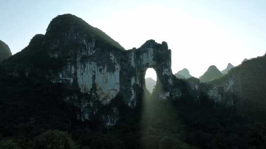 秋天阳光透过桂林山峰上的溶洞形成光束