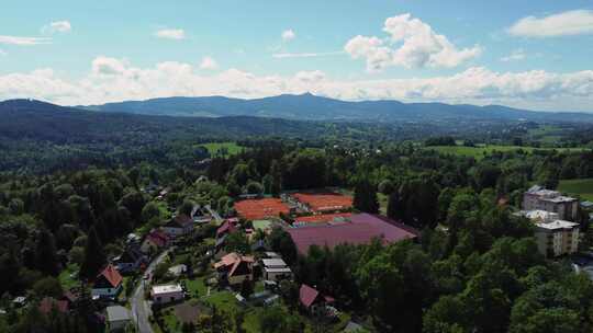 背景是利贝雷茨市Jablonec nad Nisou的房屋和网球场的无人机视图