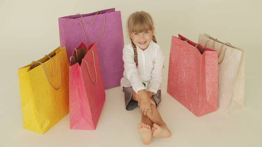 女孩坐在购物包旁边