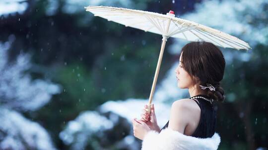 冬天下雪花纷飞打油纸伞旗袍美女在江南园林