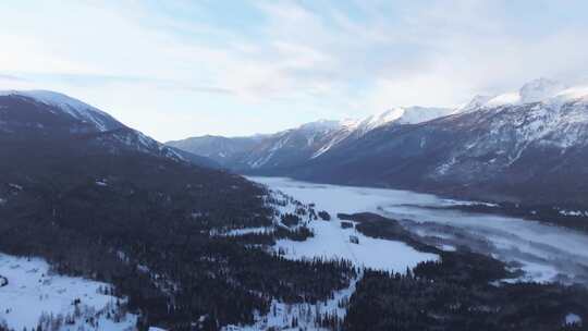 航拍新疆冬季喀纳斯河流晨雾雪山森林雪景