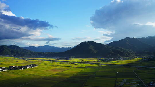 夕阳透过云层打在金黄稻田上