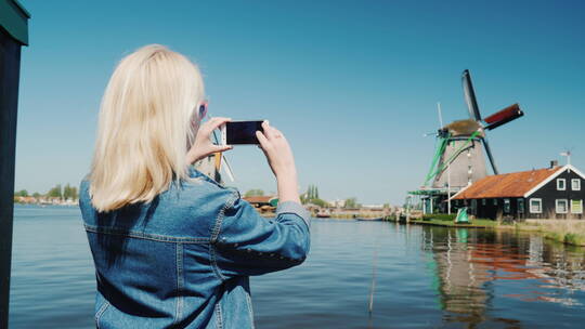 女人拍荷兰风车的照片视频素材模板下载