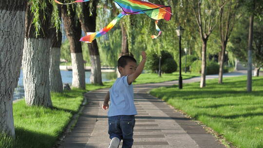小朋友在公园树林中放风筝