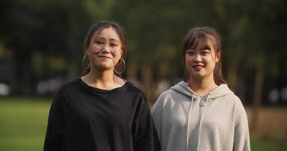 两位中国女大学生在大学校园看镜头微笑
