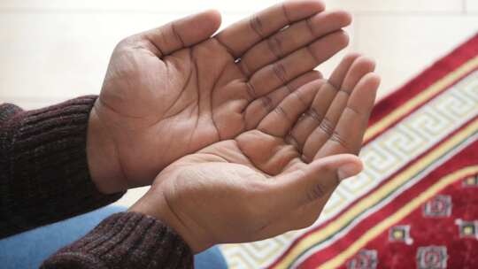 斋月特写期间，穆斯林男子保持祈祷手势