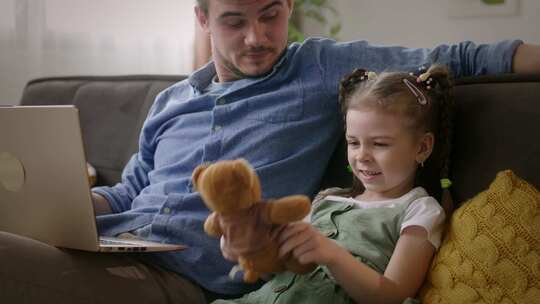 工作和娱乐父亲在家和女儿玩泰迪熊