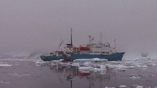一艘海洋研究船漂浮在南极洲的冰山之间