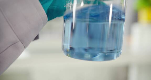 实验人员晃动观察烧杯中的蓝色溶液