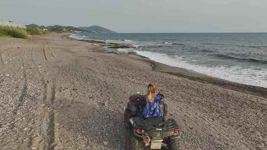 女孩在地中海海岸冒险的海岸ATV骑行天线