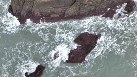 海岸礁石海水拍打礁石阴天海滩岩石海浪冲刷