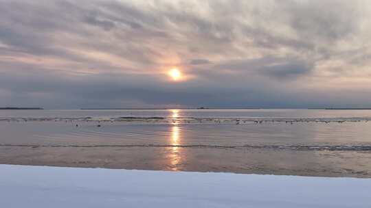 冰雪覆盖的海边日出景象