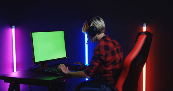 电竞玩家在绿幕电脑前打游戏