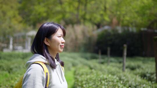 春天年轻女孩郊游茶园手拿相机拍摄美丽景色