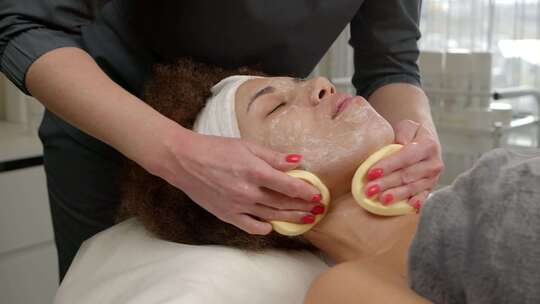 非裔美国妇女在水疗沙龙接受面部皮肤护理的