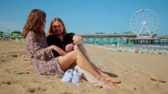 快乐的浪漫夫妇有一个第一次日期上的海滩-