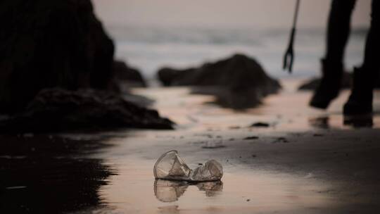 捡起海滩上的塑料瓶