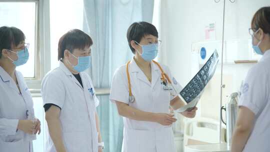 医生查看病人拍摄的CT片 询问病人