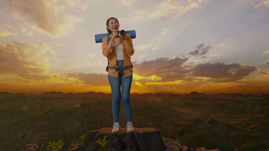 亚洲女性徒步旅行者的全身使用相机在山顶上