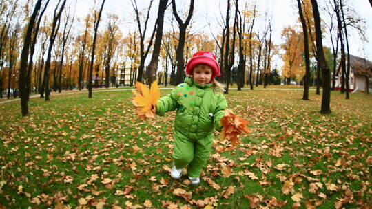 秋天小女孩在公园里跑步