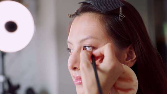 卧室里的年轻亚洲女人。美容工作室的化妆师视频素材模板下载