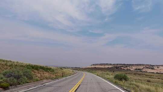 在干燥景观旁边的道路上行驶的汽车