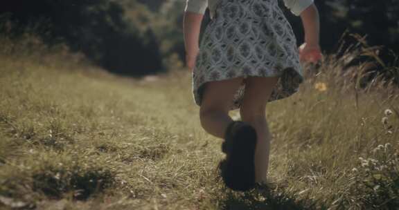 穿凉鞋的女孩穿过田野