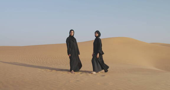 戴头巾的穆斯林妇女站在沙漠对着镜头微笑