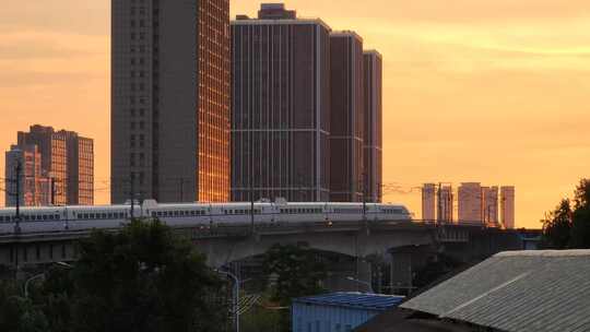 日落晚霞一列驶上铁路高架桥的动车