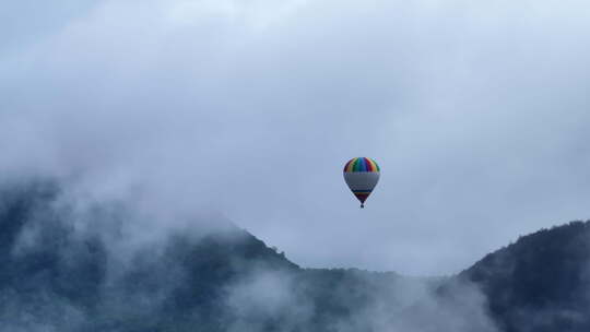 飞在云雾缭绕群山之中的热气球