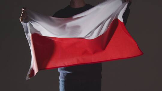 黑色背景下挥舞波兰国旗的人